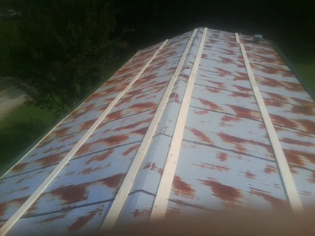 Rusted metal roof panels with new wood purlins before replacement — Storm Damage Roof Repair in Newaygo by Roofing Brothers