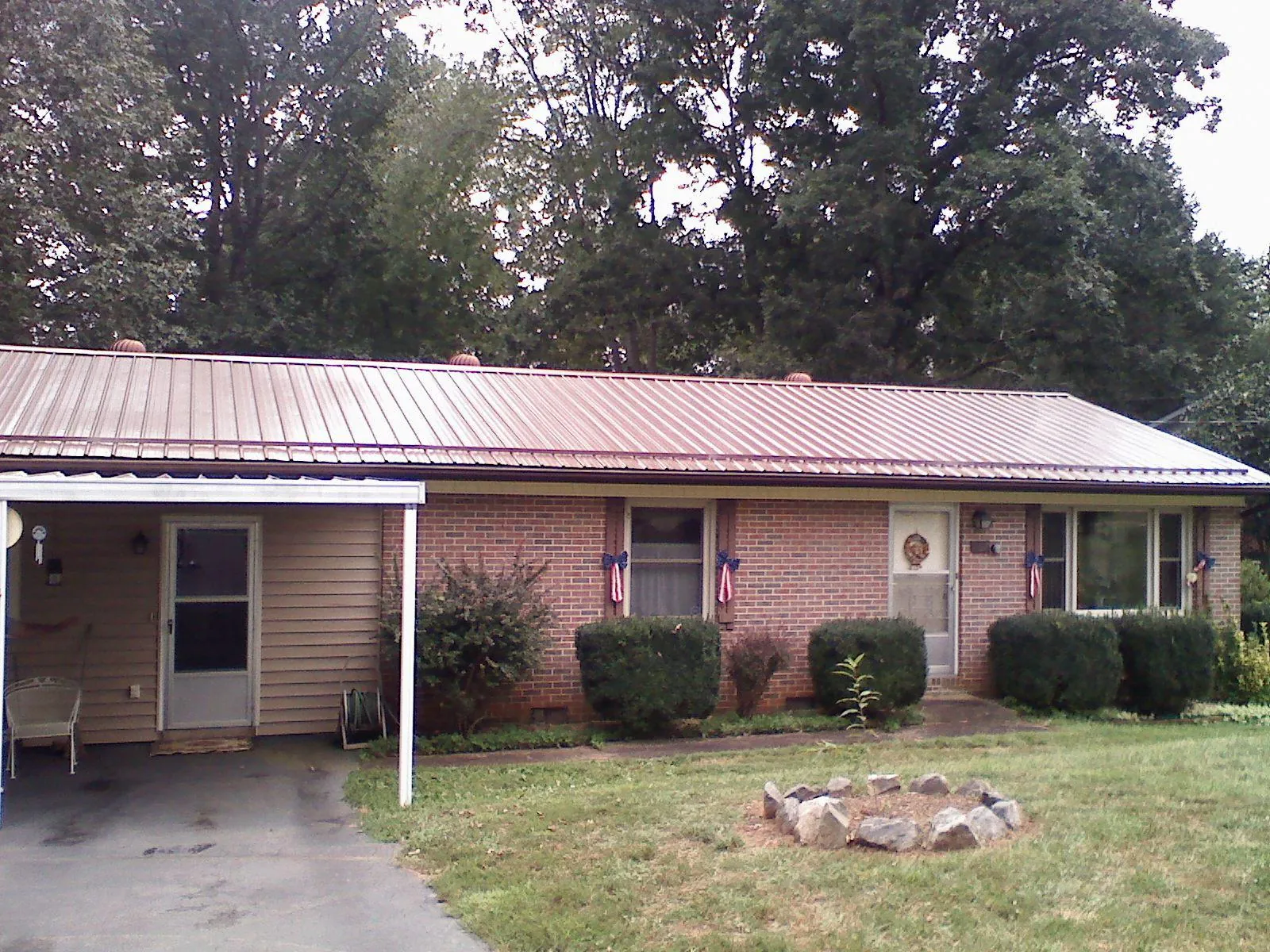Bronze metal roof and carport on a brick ranch home — Roof Repair work by our crew in Newaygo